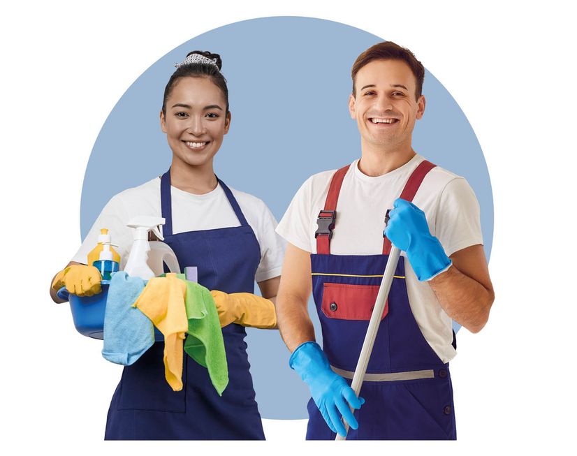 Zwei Putzkräfte mit Putzutensilien in der Hand lächeln freundlich. 