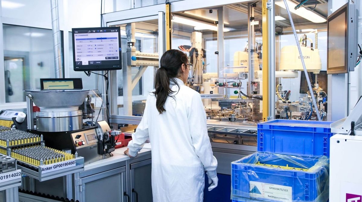 Eine Mitarbeiterin vor einer Maschine im Sauberraum bei Magnetbau Schramme 