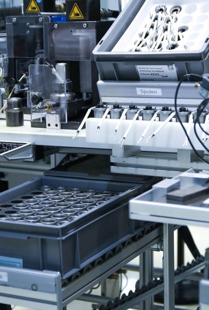 Eine Mitarbeiterin vor eine Maschine in der Montage bei Magnetbau Schramme
