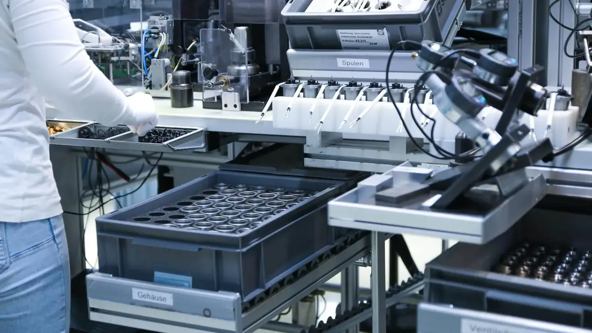 Eine Mitarbeiterin vor eine Maschine in der Montage  bei Magnetbau Schramme 